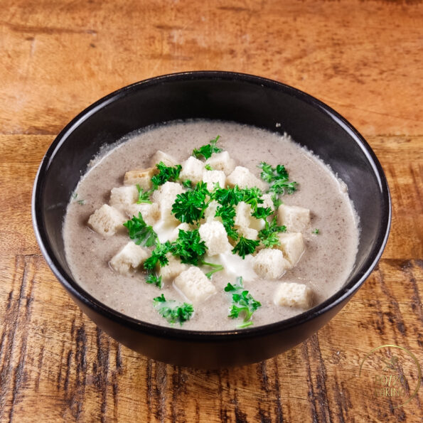 Creamy champignon soup with sour cream, parsley and croutons