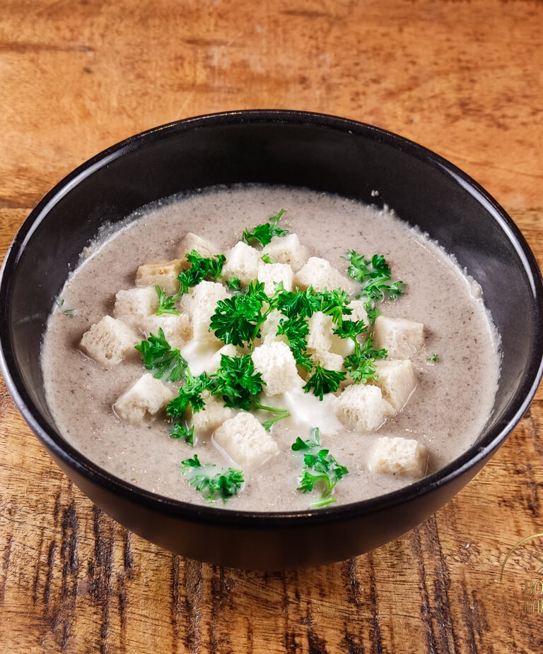 Creamy champignon soup with sour cream, parsley and croutons